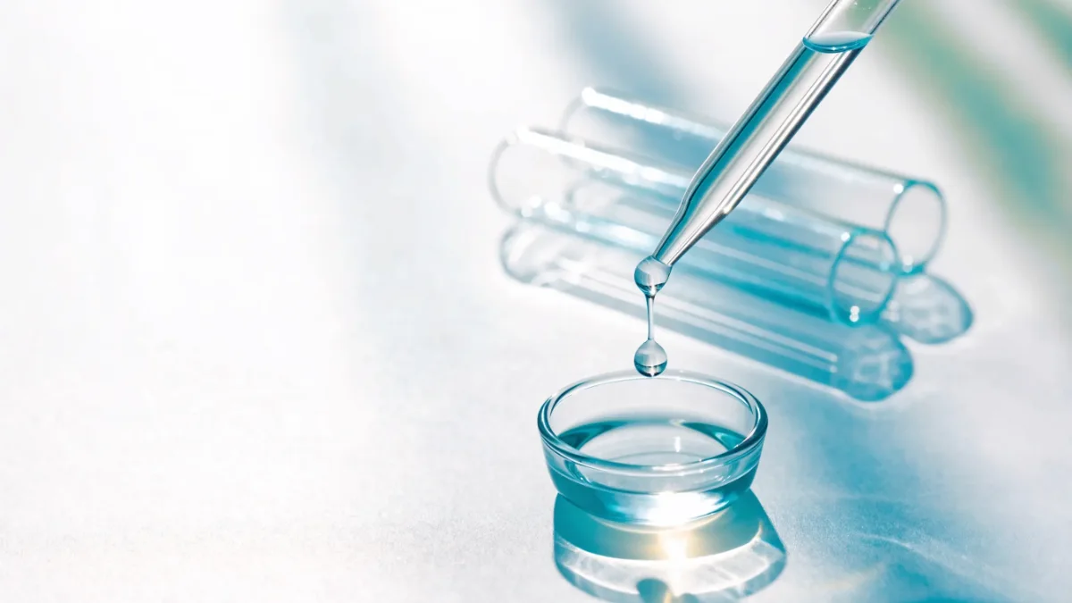 Laborpipette gibt einen Tropfen in eine Glasschale